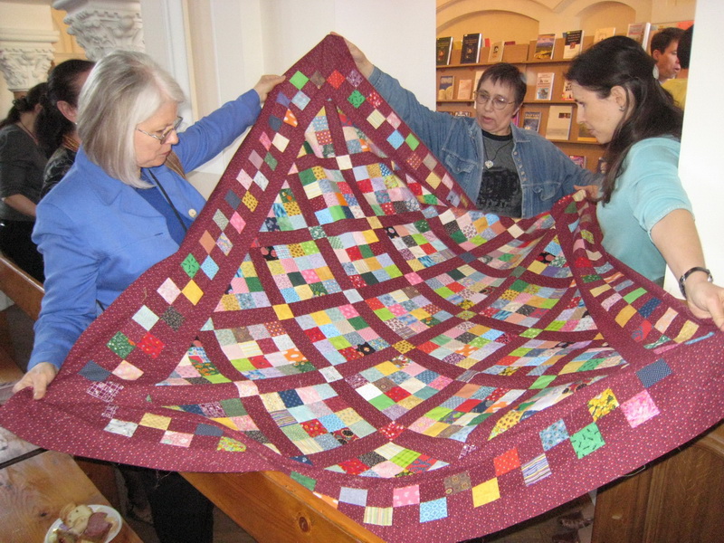 Darlene, Jhenya & Andrea with Quilt at church